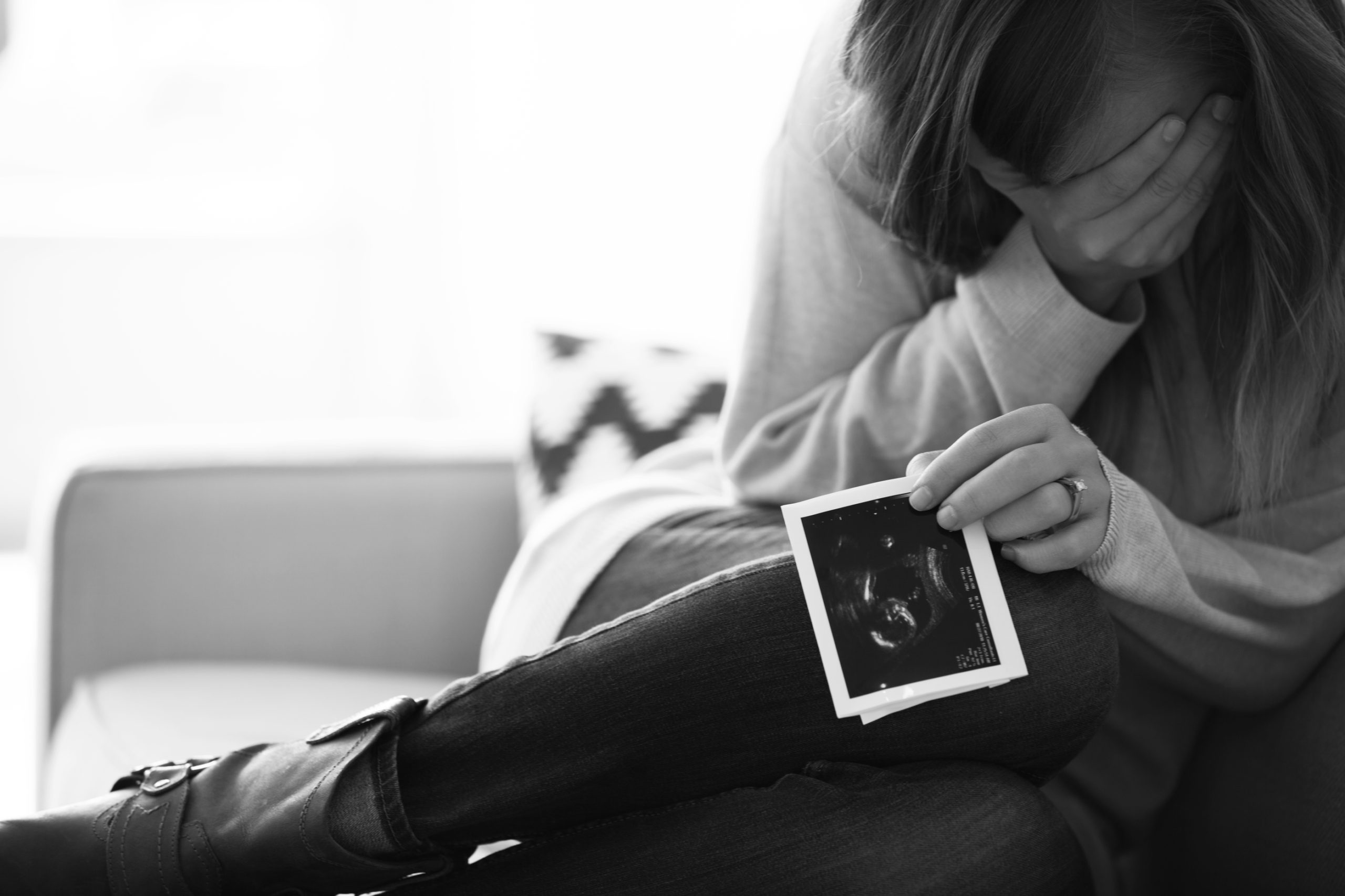 woman crying holding an ultrasound photo